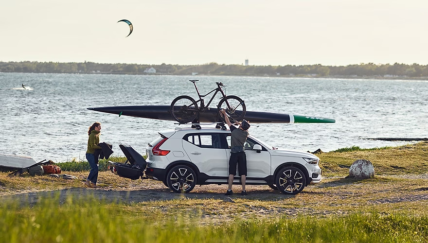 Two people using Thule accessories attached to the vehicle