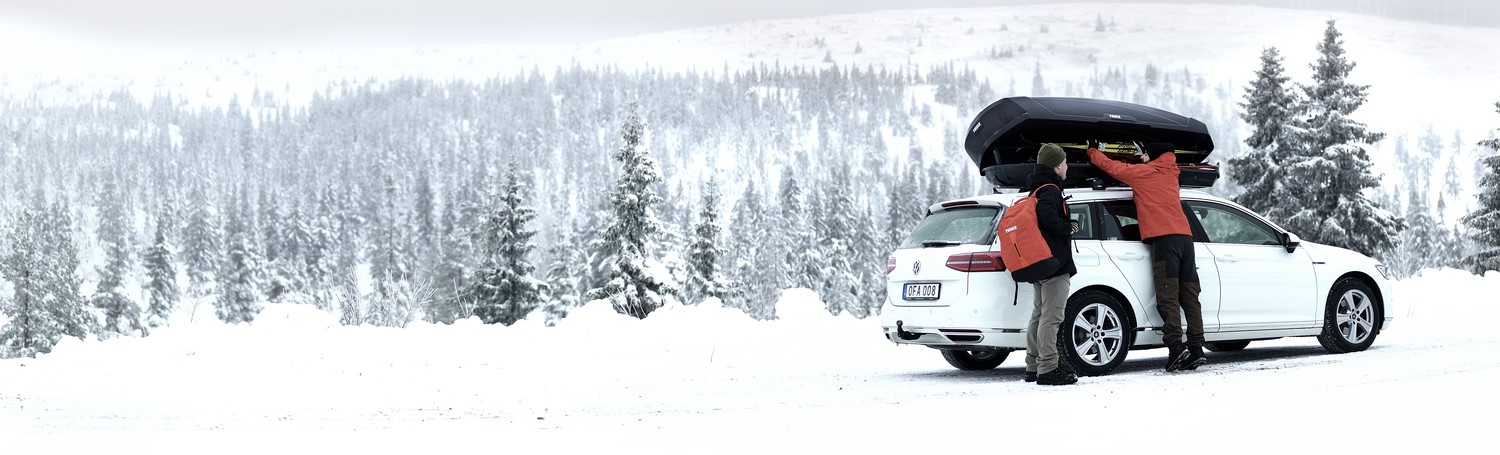 Car with roof box installed in a wintery scene